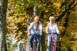 Photo of a Couple Bicycling in the Fall. Click Here for 20 Fall Date Ideas.