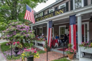 The romantic MA lodging Concord's Colonial Inn can be seen, decorated in floral and patriotic dressings.